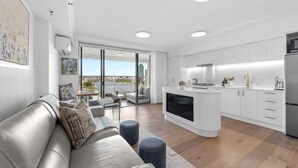 A modern living room with a sofa, ottomans, and a fireplace. - Sweet! 1Bed, 1Bath, 1Car, VIEWS ~ CBD (Brisbane City)
