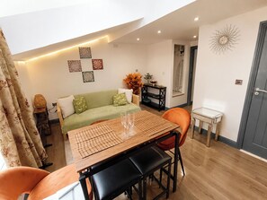 Ein modernes Wohnzimmer mit Esstisch, Sofa und Wanddekoration.