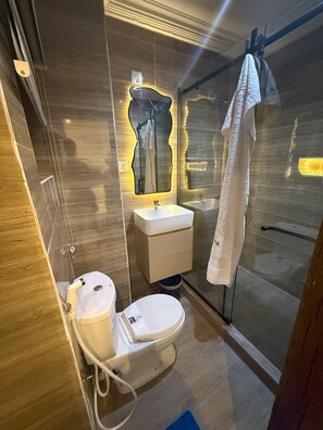 Een douche, handdoeken, zeep, toiletpapier