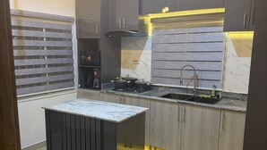 A modern kitchen with a central island, built-in appliances, and under-cabinet lighting.