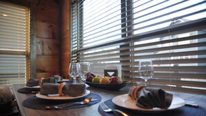 A dining table set with plates, cutlery, napkins, and a fruit bowl. - Modern•Prime Location•Mountain Views•Theater•Hot Tub•minutes to ALL attractions! (Sevierville)