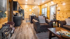 A cozy cabin interior with a kitchen, dining area, and seating. - Modern•Prime Location•Mountain Views•Theater•Hot Tub•minutes to ALL attractions! (Sevierville)