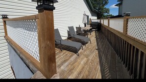 A wooden deck with a white fence, a wooden railing, and a small table with chairs. - Whole House to Yourself! Cozy Suburban Getaway Near Riverside Pathways  (Calgary)