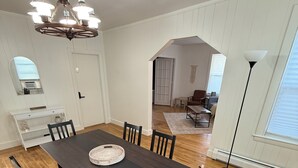 A dining area with a dark wooden table, six chairs, and a chandelier.