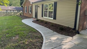 A single-story house with a brick facade, beige siding, and a front yard with a curved concrete path. - Chic 3 Bedroom Midcentury Modern Retreat in Wonderful Greensboro (Greensboro)