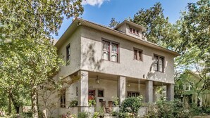 A two-story house with a porch, columns, and a number '303' on the front door.