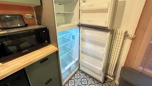 Eine Küche mit Mikrowelle, Toaster und einem Kühlschrank mit zwei Türen.