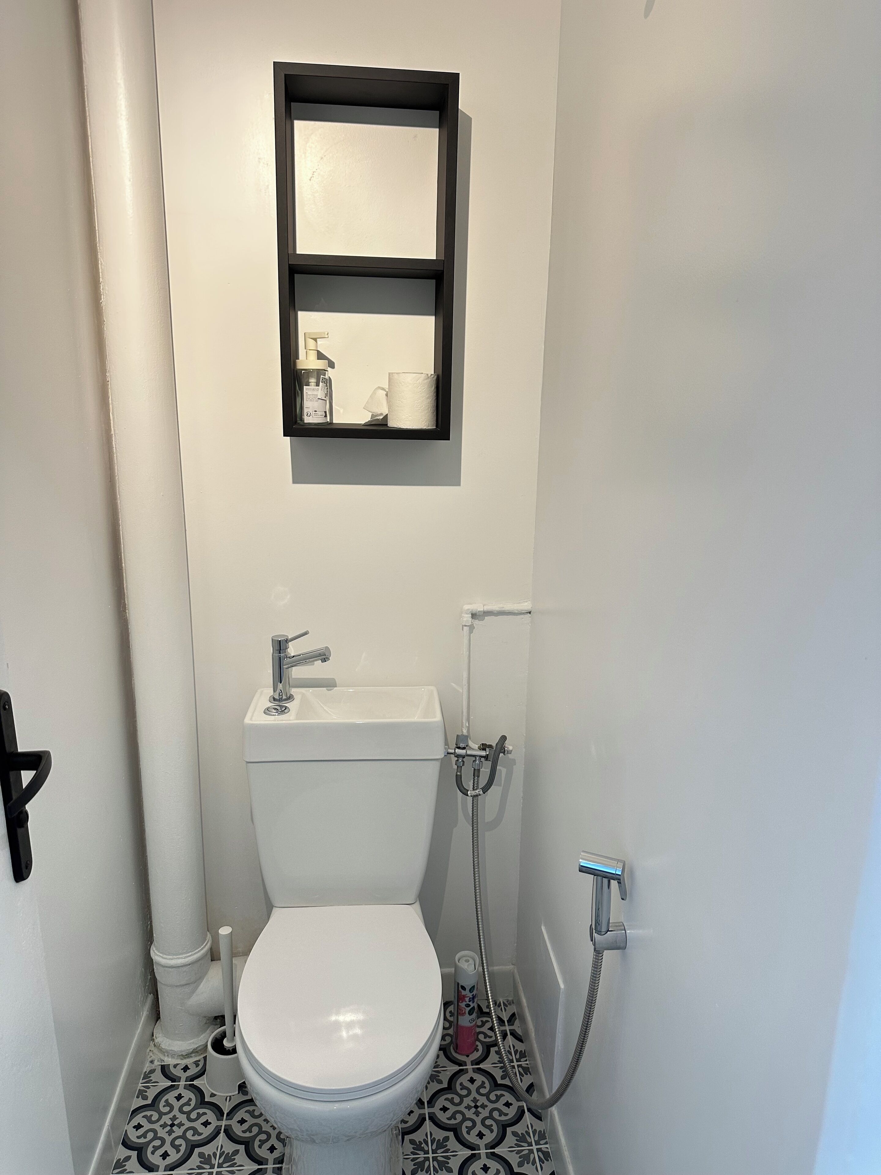 Un baño pequeño con inodoro, lavamanos y ducha.