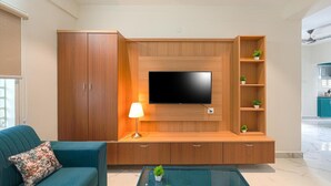 A living room with a TV wall unit, wooden cabinets, a sofa, and a coffee table. - Enjoyable building with AC in vibrant Hyderabad (Hyderabad)