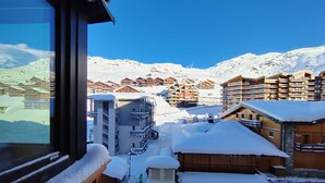 Estância de montanha coberta de neve com edifícios de madeira e céu azul claro.