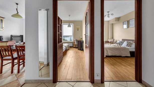 En moderne lejlighed med spiseplads, et soveværelse med en stor seng og et arbejdsområde med skrivebord og stol.