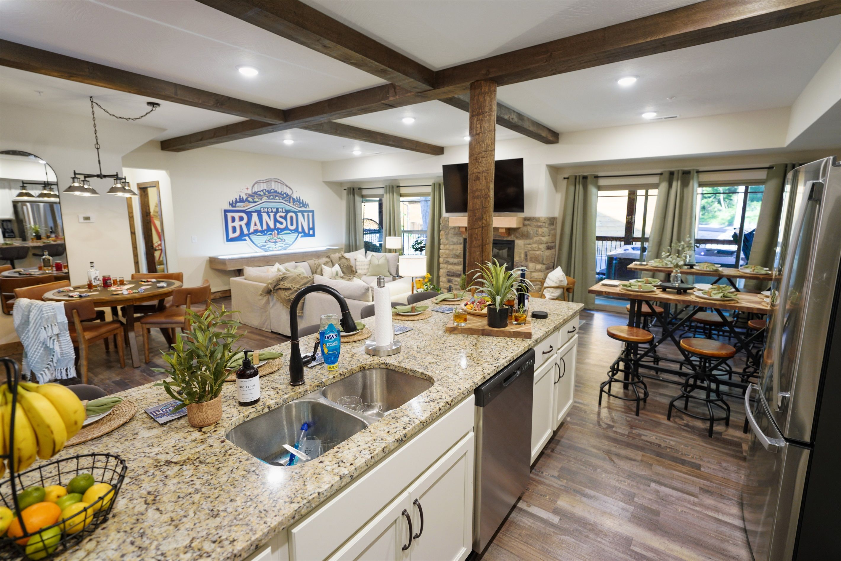 A spacious kitchen with granite countertops, a dishwasher, and a dining area with bar stools.