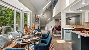 A spacious kitchen with a large island, a dining area with blue chairs, and a view of the outdoors. - 7k sq/ft! Gym, Theatre, Hot Tub, Sauna, Game Room, Golf, Sleeps 28 - Family Fun! (Colorado Springs)