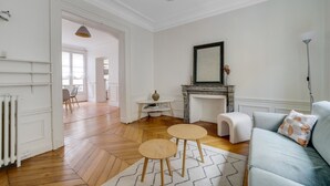 A spacious living room with a fireplace, a sofa, and a dining area with chairs. - République Of City Paris (Paris)
