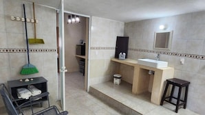 A bathroom with a sink, mirror, and a broom rack.