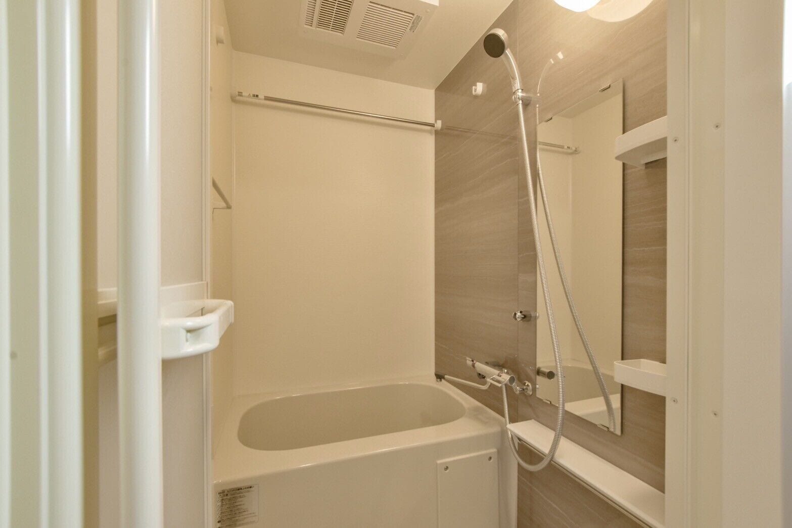 A modern bathroom with a bathtub, shower, and a glass shower enclosure.