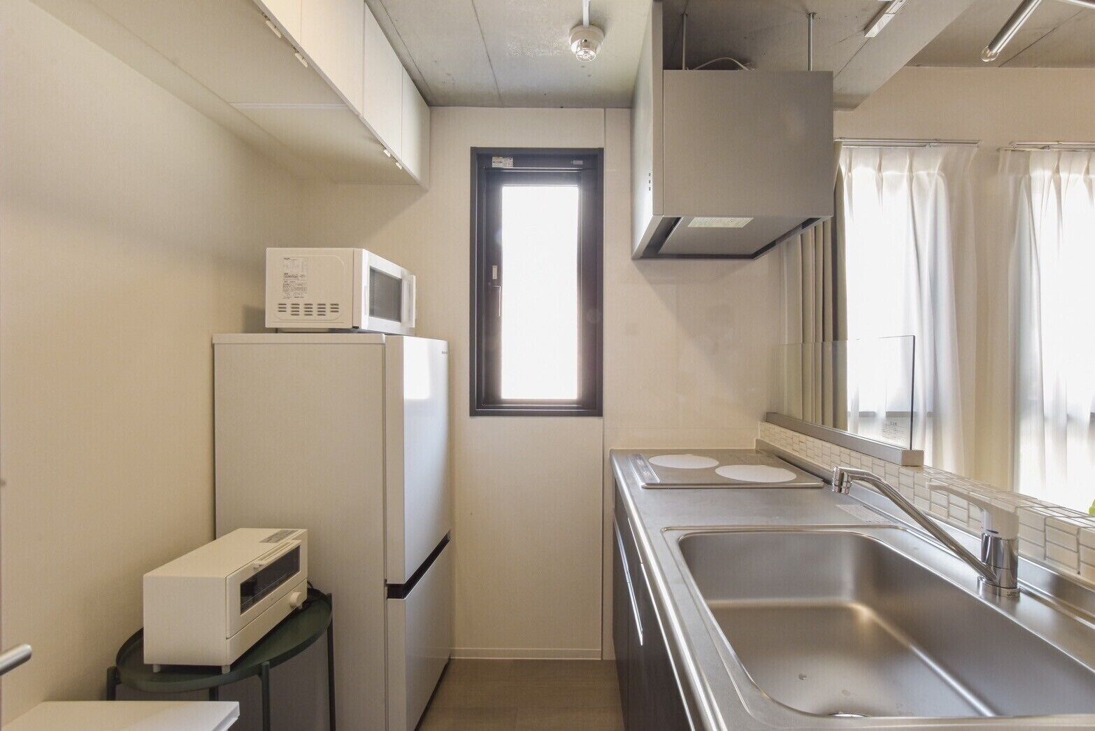 A compact kitchen with a microwave, refrigerator, and sink.
