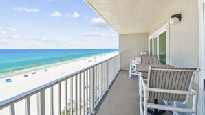 A balcony with a view of a beach and ocean.