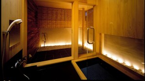 A sauna with wooden walls and a glass door, a bench, and a small pool. - Linca (Zushi)