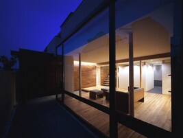 A modern interior with a wooden floor, a staircase, and a seating area.
