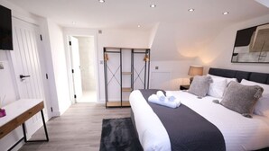 A modern bedroom with a large bed, a desk, and a walk-in closet. - Market Street 61A (Watford)