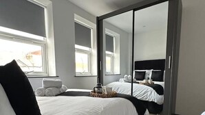 Una habitación de hotel moderna con una cama grande, un armario y vistas a la ciudad.