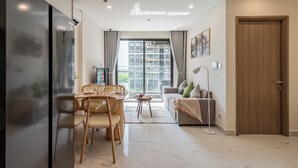 Una sala de estar moderna con comedor, ventanas amplias y vistas a un paisaje urbano.