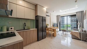 Una cocina moderna con horno integrado, refrigerador y comedor con mesa y sillas.