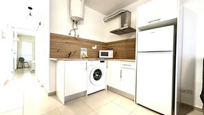 Una cocina moderna con lavadora, microondas y refrigerador.