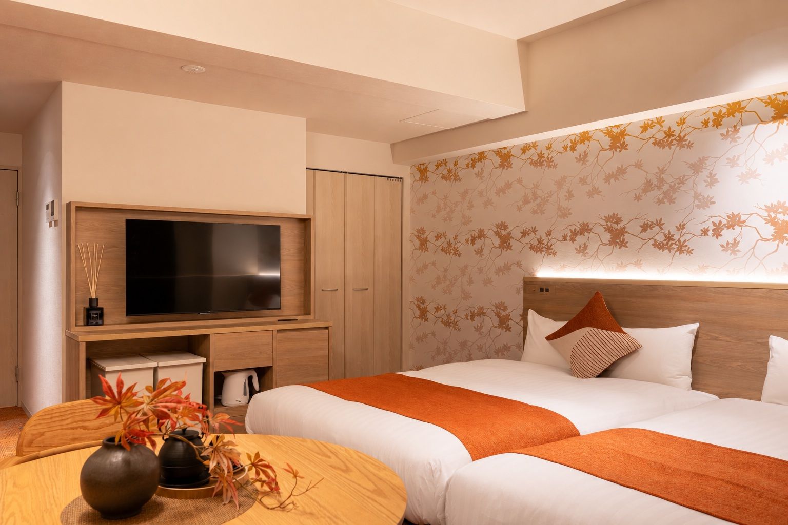 A hotel room with a bed, a TV, a desk, and a decorative wall.