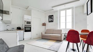 A modern kitchen with white cabinetry, a built-in oven, and a microwave. - Appartement Cosy à Bastille - 4 guest - Paris 4 (Paris)