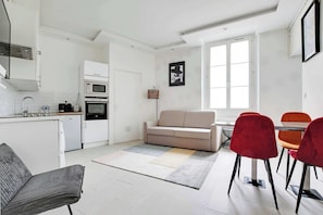 A modern kitchen with white cabinetry, a built-in oven, and a microwave. - Appartement Cosy à Bastille - 4 guest - Paris 4 (Paris)