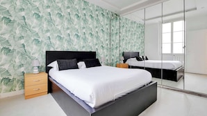 A modern bedroom with a large bed, a nightstand, a dresser, a mirror, and a window. - Appartement Cosy à Bastille - 4 guest - Paris 4 (Paris)