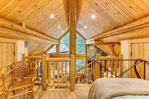 A wooden cabin interior with a high ceiling, a stone fireplace, a wooden chair, and a bed. - Stunning Views! Ski-In/Out Mountain Village Cabin (Mountain Village)