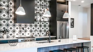 A modern kitchen with a central island, stainless steel appliances, and pendant lighting.