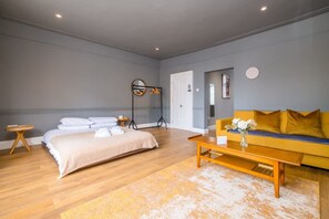 A modern bedroom with a bed, a sofa, a coffee table, and a mirror. - Host Stay St James Opulence (Brighton)
