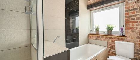 Une salle de bain moderne avec une douche à parois de verre, une baignoire sur pieds et des toilettes.