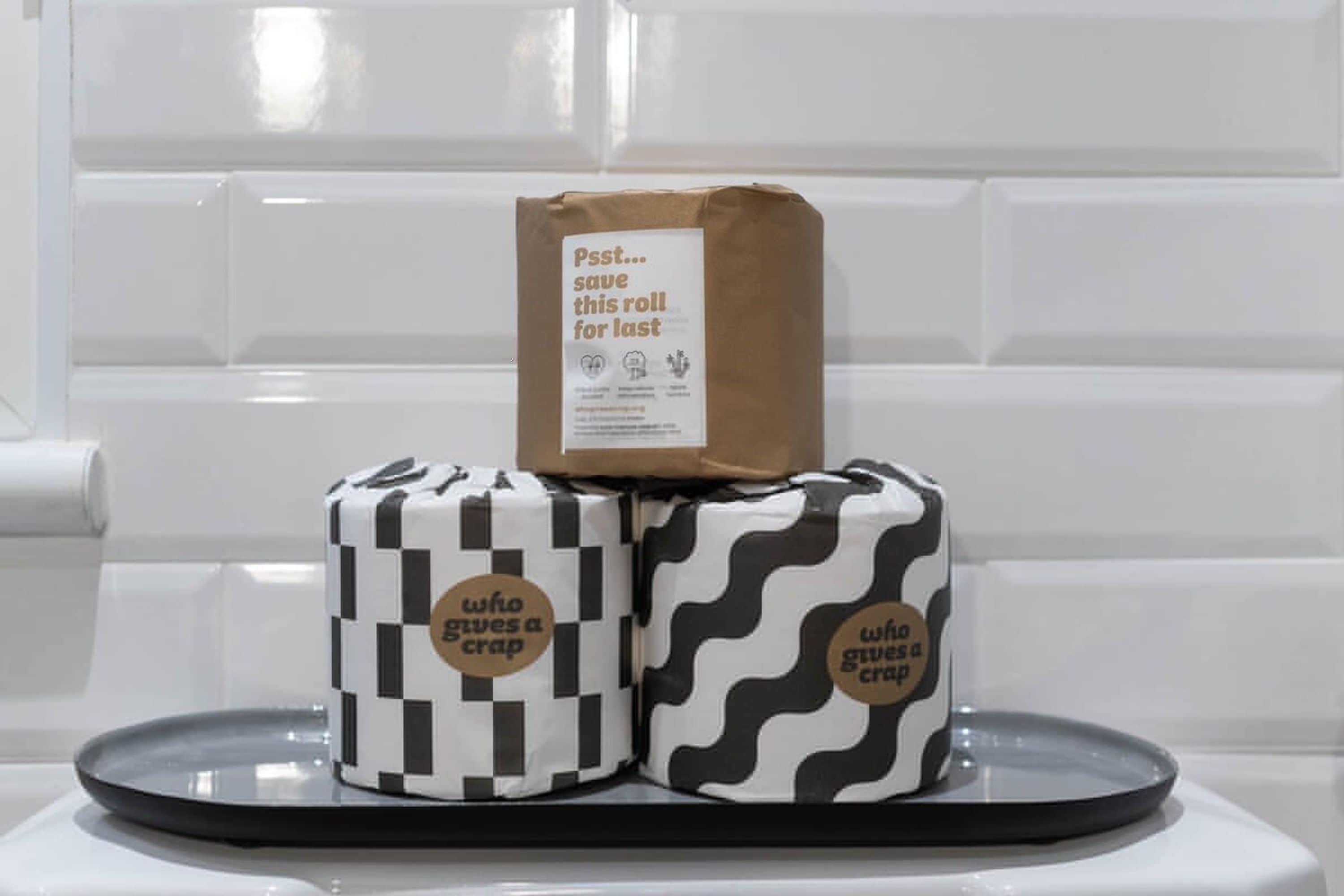 Dois presentes embalados, com a etiqueta 'who gives a crap', sobre uma bandeja.