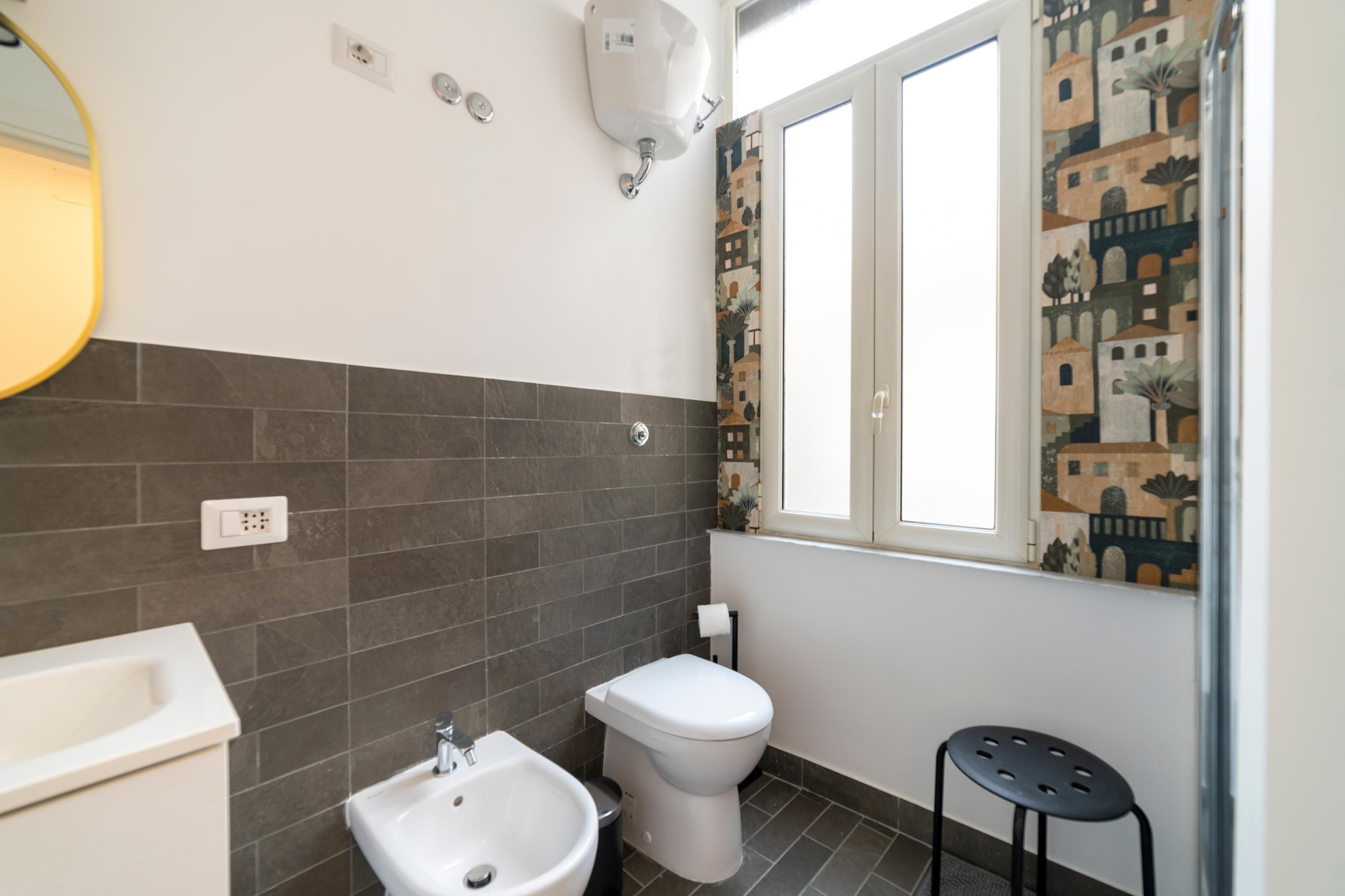 A bathroom with a sink, toilet, and a mirror.