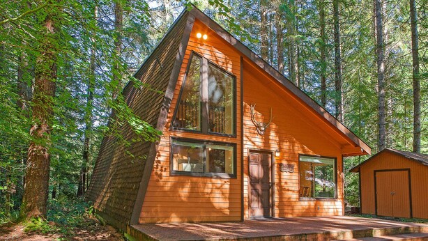 A wooden cabin with a large window, a door, and a small shed. - Lindgren Hause in Enumclaw (Enumclaw)