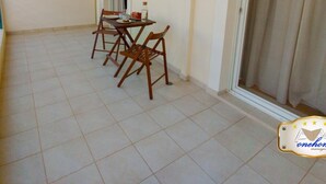 A corridor with a dining area featuring a table and chairs, an air conditioning unit, and a sliding glass door. - Filoxenia in the Centre of Kalamata (Kalamata)