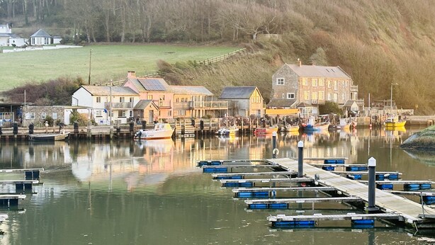 A harbor with boats docked, a pier, and buildings along the water's edge. - Littlefields in Seaton (Seaton)