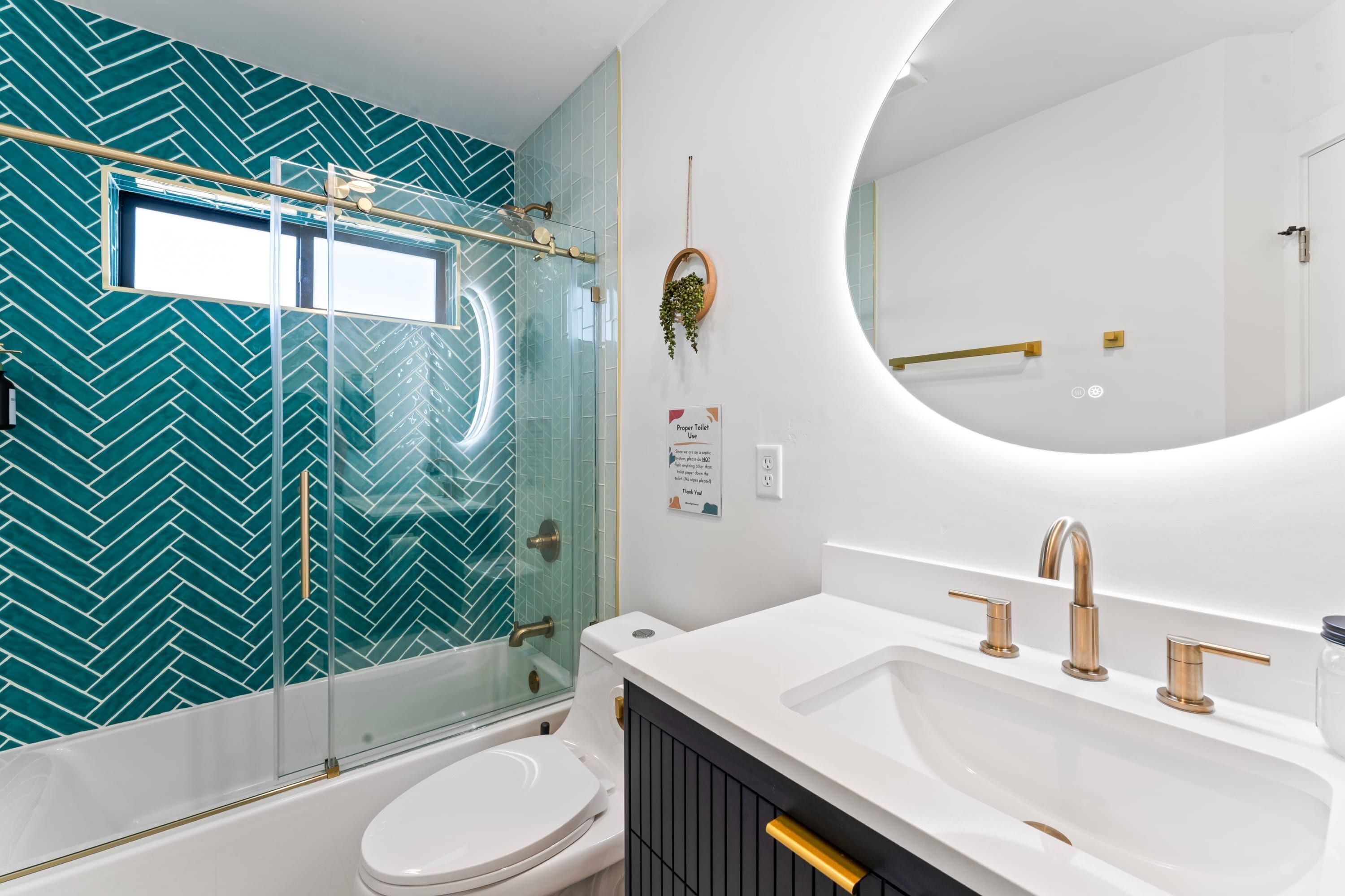 A modern bathroom with a glass shower enclosure, a white toilet, a vanity with a sink, and a large mirror.