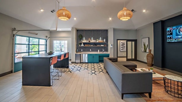 Una cocina moderna con una isla central, barra y zona de estar.