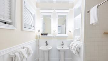 Un baño con dos lavamanos, un espejo y un perchero para toallas.