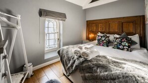 A bedroom with a bed, a window, a nightstand, and a wardrobe. - Host Stay The Chapel in Thornham (Hunstanton)