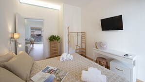 Une chambre d’hôtel moderne équipée d’un lit, d’un bureau, d’une télévision et offrant une vue sur la cuisine et le balcon.