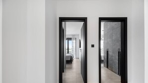 Un couloir moderne au design minimaliste, caractérisé par une palette de couleurs neutres et un espace épuré et dégagé.