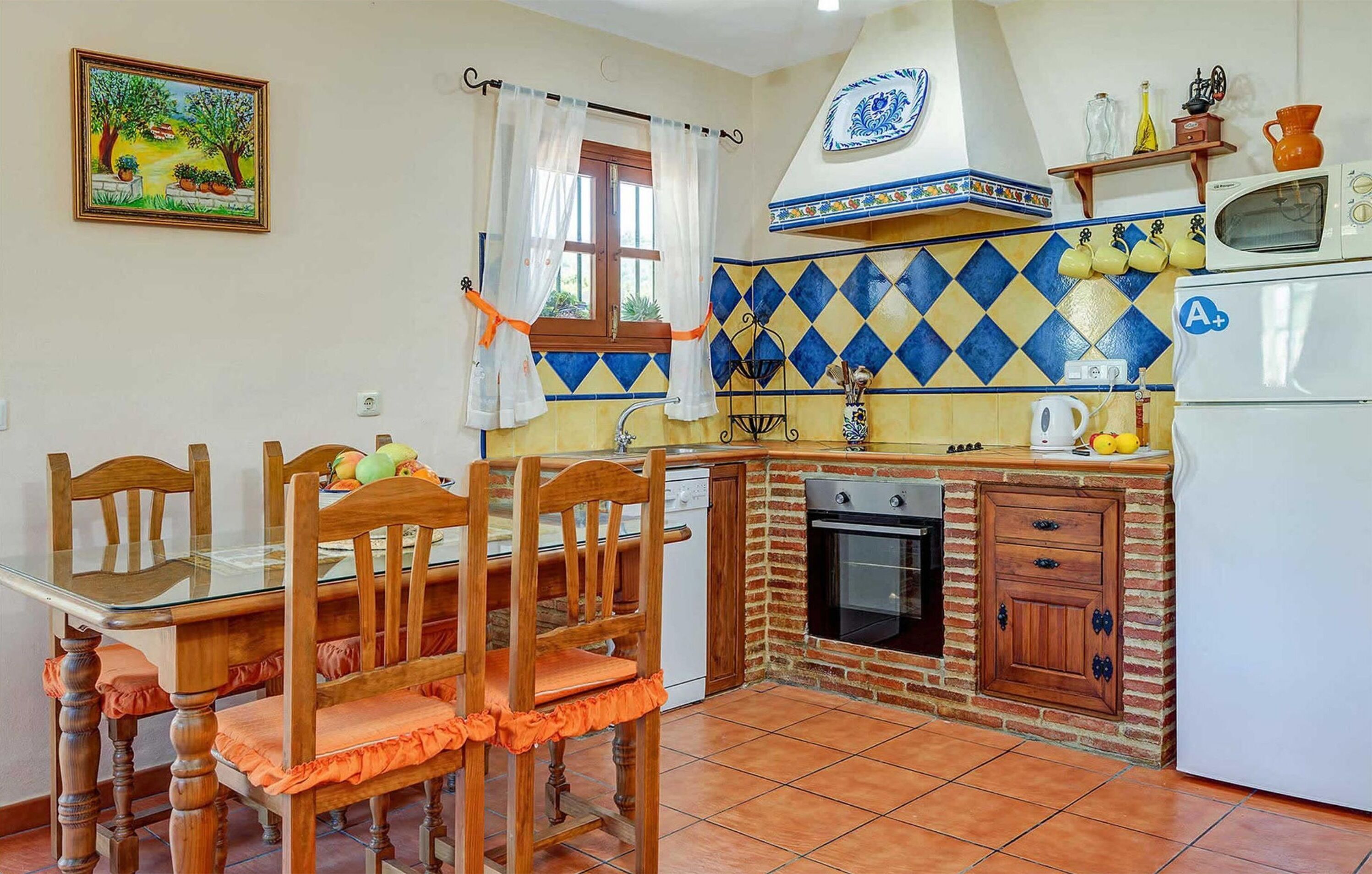 A kitchen with a dining table, chairs, a sink, a stove, and a refrigerator.