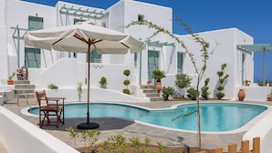 A modern white building with a swimming pool, outdoor furniture, and potted plants. - Beachside Bliss at Skyros Luxury Retreat (Skiros)